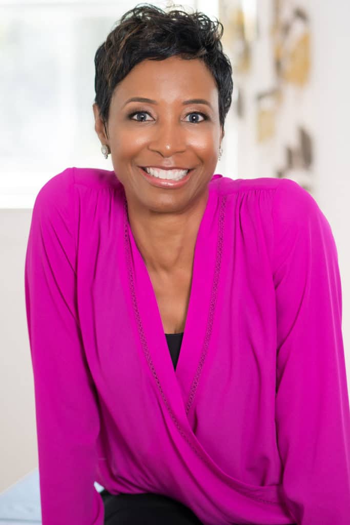 Keynote speaker Theresa M Robinson smiling and wearing a pink top