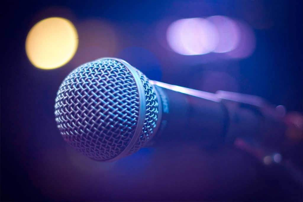 keynote speaker microphone with stage lights in the purplr background