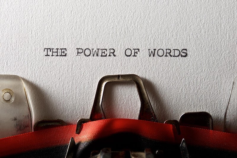 Typewriter with red ribbon and paper with the sentence The Power of Words